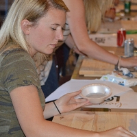 A young alumni woman painting